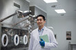 © ReeldealHD images - Male scientist walking through pharmaceutical manufacturing laboratory carrying a digital tablet