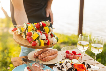 Wall Mural - Crop man serving skewers for picnic