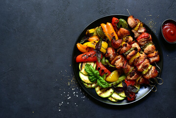 Chicken kebab skewers with grilled vegetables. Top view with copy space.