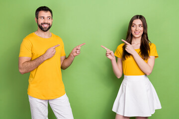 Wall Mural - Photo of two cheerful nice people look each other direct fingers isolated on green color background