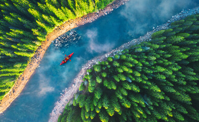 Wall Mural - aerial view of rafting boat or canoe in mountain river and forest. recreation and camping