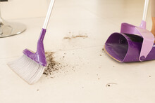 Broom With Dirt By Dustpan On Tiled Floor At Home