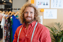 Portrait Of Smiling Caucasian Mid Adult Male Fashion Designer With Long Hair In Office Studio