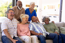 Cheerful Multiracial Male And Female Senior Friends Laughing While Relaxing In Nursing Home