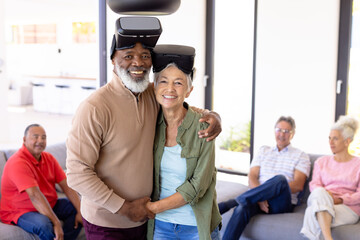 Wall Mural - Portrait of happy multiracial senior friends wearing virtual reality simulators in retirement home