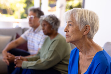 Wall Mural - Asian sad senior woman with multiracial friends sitting on sofa in nursing home