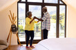 African american senior friends doing salsa dance by window in nursing home