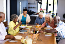 Multiracial Senior Friends Having Lunch On Dining Table At Nursing Home