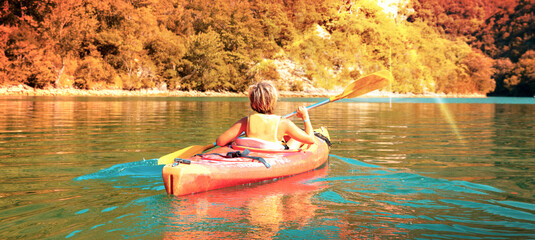 Wall Mural - children canoeing in the river at sunset