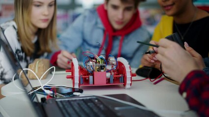 Wall Mural - group of high school students building and programming electric toys and robots at robotics classroo