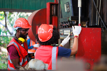 Wall Mural - Training trainee concept. Yang male african american engineer explain the procedure for using the correct metal machine look at online  manual in laptop at factory.