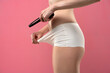 © vladimirfloyd - woman looks at her crotch with a magnifying glass on a pink studio background