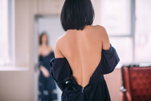 Woman Takes Off A Dress The Sexual Undresses In Front Of A Mirror. Back View