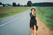 happy woman in a hat travels with a suitcase on the road hitchhiking and makes a sweetheart kiss. retro style.