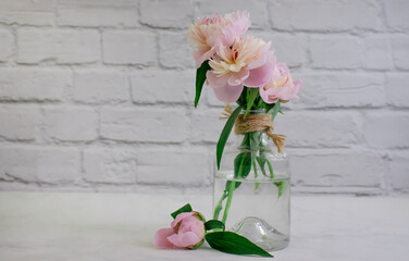 Beautiful peony flower in a vase on an old background