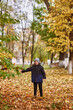 © Екатерина Мазур - A boy plays leaves in the fall near school. School change fall boy 8 years old game fall leaves . all yellow autumn