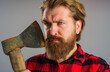 Serious bearded man with hatchet. Canadian lumberjack with old axe. Cutting wood. Logger tools.