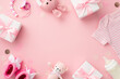© ActionGP - Baby girl concept. Top view photo of gift boxes shirt booties knitted bunny rattle toy teddy-bear pacifier chain bottle and confetti on isolated pastel pink background with copyspace in the middle