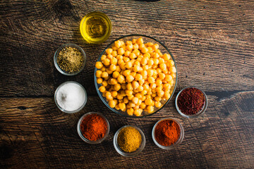 Canvas Print - Ingredients for Sumac and Spice Roasted Chickpeas: Overhead view of canned garbanzo beans, olive oil, and spices in small glass bowls