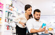 © JackF - Courteous woman helping man in a wheelchair to choose the right medicine in a pharmacy