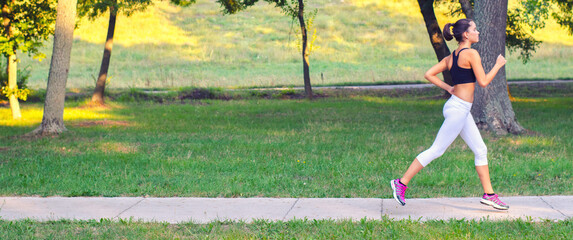 young fitness woman running in the summer nature