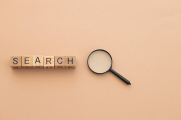 Wall Mural - magnifying glass on beige background. Search concept