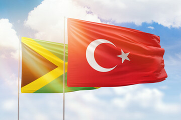 Sunny blue sky and flags of turkey and jamaica