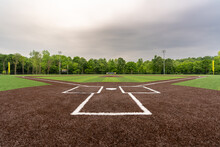 View Of  High School Synthetic Turf Baseball Field Looking From Batters Box Toward The Outfield.