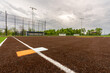 View of softball high school field double first base with second orange safety base, looking toward third late.