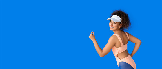 Poster - Sporty running African-American woman on blue background with space for text