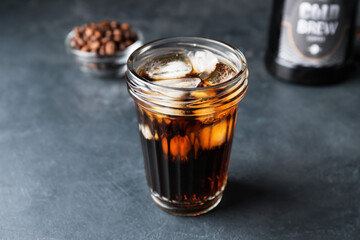 Glass with cold brew coffee on dark table, closeup