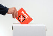 Wahl - Hand mit Stimmzettel und Wahlurne