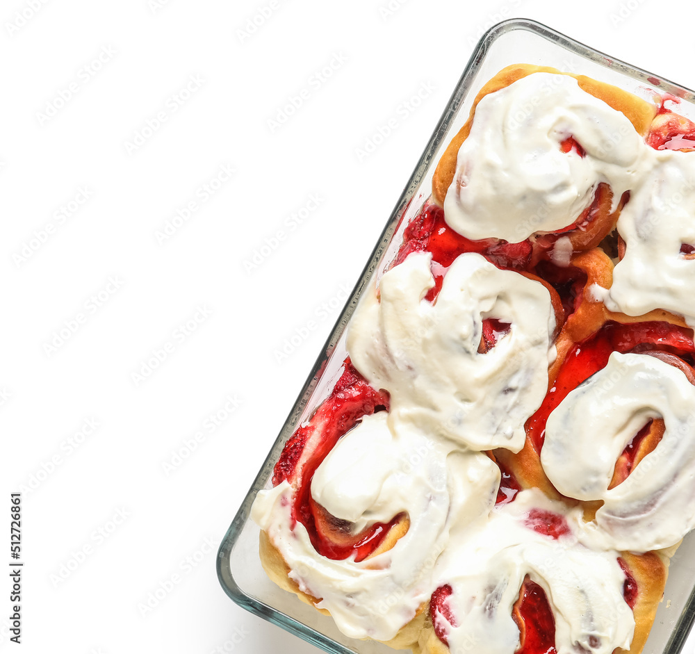 Baking dish with strawberry cinnamon rolls and cream on white background