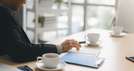 Wall Mural - No face closeup hand young adult business man place on work table boardroom in office