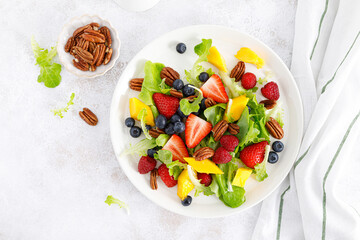 Sticker - Fruit and berry salad with strawberry, blueberry, raspberry, mango and pecan nuts. Healthy food, diet. Top view