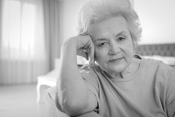 Portrait of mature woman in living room. Black and white photography