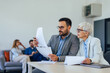 © bnenin - Focused businesspeople checking some documents, at the co-working space.