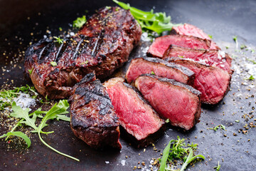 Wall Mural - Barbecue dry aged wagyu roast beef steak with lettuce and spice served as close-up on a rustic black board