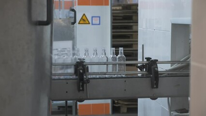 Wall Mural - Glass bottles on conveyor production line in beverage factory.