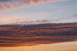 Blue-pink clouds in the light of the setting sun. Sun illuminates cirrocumulus clouds