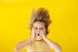 Surprised child against yellow background