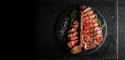 Wall Mural - Dry Aged Barbecue Porterhouse Steak T-bone beef steak sliced with large fillet piece with herbs and salt. American meat restaurant