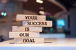 Wooden blocks with words 'Your success is our goal'. Business concept