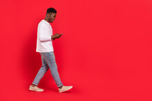 Full Size Profile Portrait Of Cheerful Person Walk Use Telephone Chatting Isolated On Red Color Background