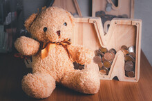 Wooden Piggy Bank With Brown Teddy Bear. Money Saving Concept. Vintage Picture Style.