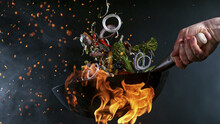 Freeze Motion Of Wok Pan With Flying Ingredients In The Air And Fire Flames.