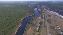 Aerial Video Of A River Passing Through A Coniferous Forest And A Small Town