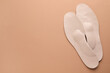 © New Africa - Orthopedic insoles on pale pink background, flat lay. Space for text