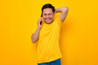 © Sewupari Studio - Cheerful young Asian man in casual t-shirt talking on mobile phone and laughing out loud, reaction to joke isolated on yellow background. People lifestyle concept
