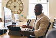 © Southworks - Young creative black man working on computer in modern office at desk on tablet computer
